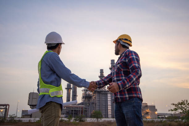 Engineers shaking hands at power plant after success day